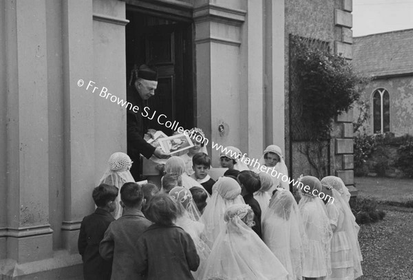 PARISH SCENE  GROUP OF CHILDREN WITH PRIEST ON DOORSTEP OF HOUSE